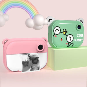 Kids instant print camera in pink and green with cute animal designs and rainbow background