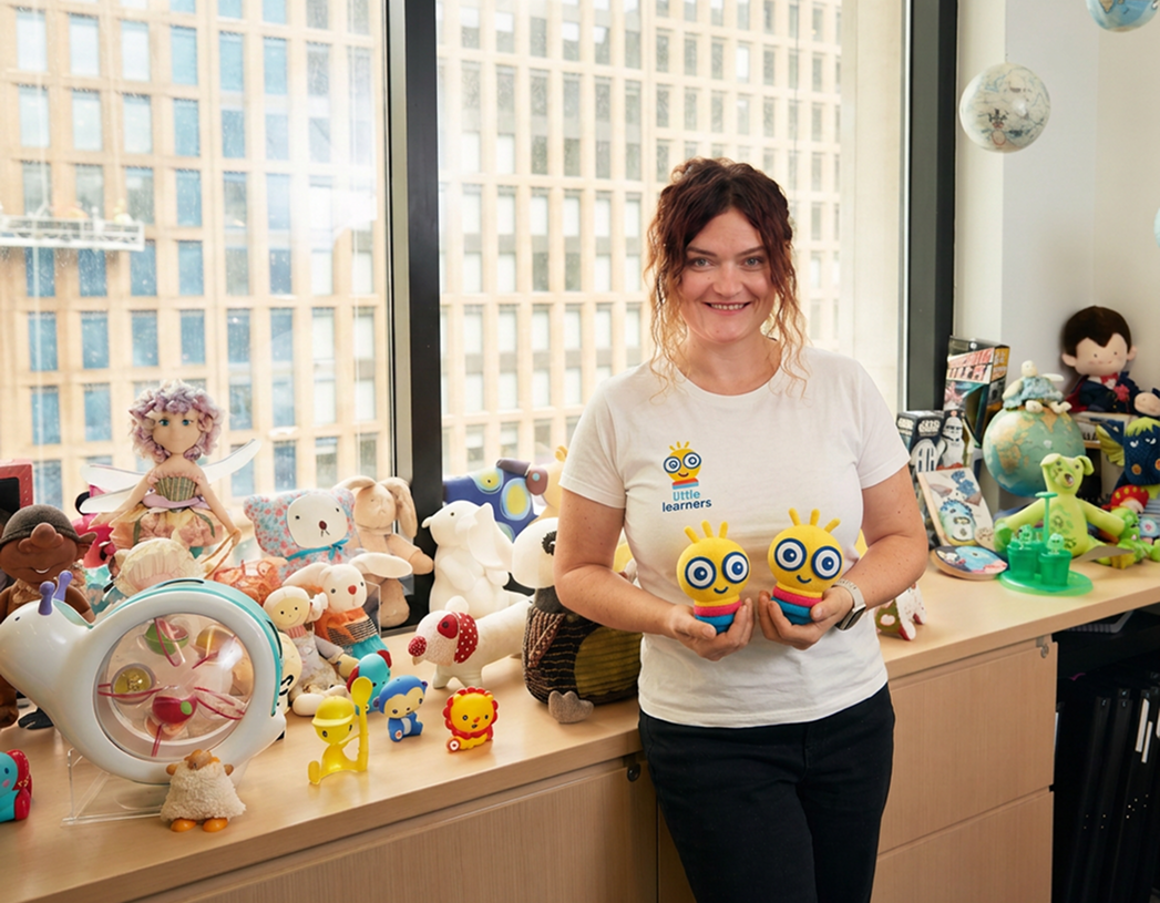 Sarah holding two Little Learners mascots in the office