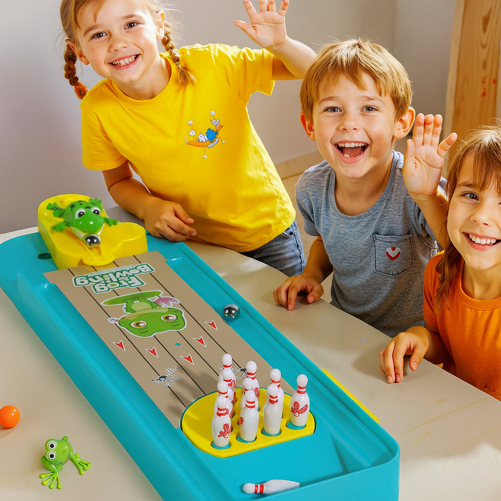 Children playing educational bowling and basketball game for kids with frog catapult toy on a table indoors